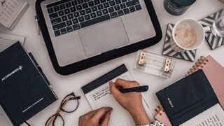Seorang penulis blog yang sedang mengetik di laptop. (Alt: Menulis konten berkualitas untuk menarik pembaca blog.)